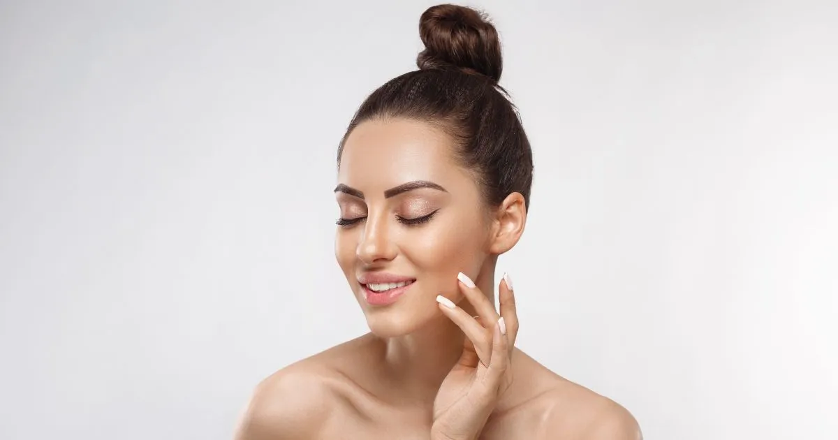 Beautiful woman with flawless skin touches her cheek after a Frost Aesthetic Consultations in Mesa, AZ